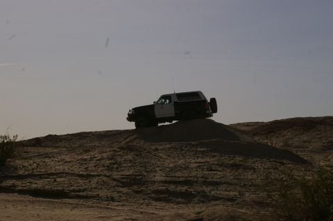 1986 Ford Bronco - 1986 Ford Bronco navigates a sandy terrain, its off-road capability.