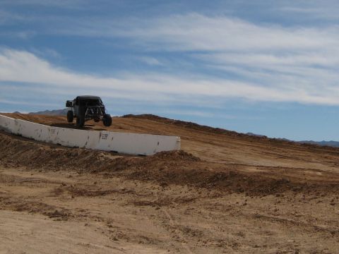 1996 Ford Bronco - Off-road buggy airborne during a jump on a dirt track.