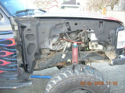 1996 Ford Bronco - Close-up view of the front fender well and suspension components of a modified truck.