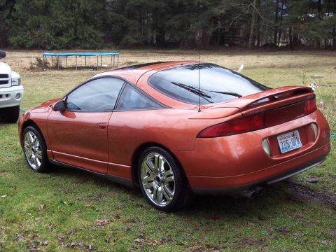 1995 Mitsubishi Eclipse - This 1995 Mitsubishi Eclipse is shown in an orange finish from a rear-three-quarter perspective.