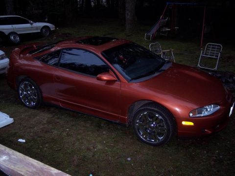 1995 Mitsubishi Eclipse - This 1995 Mitsubishi Eclipse coupe is shown from a three-quarter front angle, parked outdoors with another vehicle in the background.