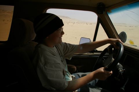 1986 Ford Bronco - Interior view of a person driving a vehicle through a desert landscape.