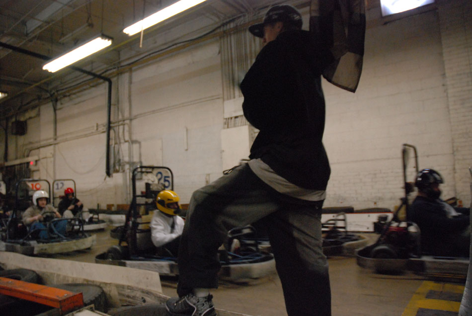 Go-karts with drivers wearing helmets in an indoor track