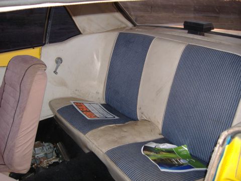1987 Ford Crown Victoria LTD - The interior of a car shows worn seats and a carburetor on the floor, with a 'For Sale' sign on the seat.