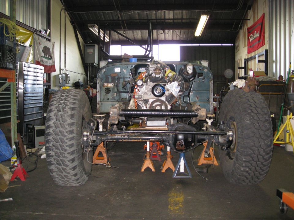 Jeep YJ chassis on jack stands, engine exposed, large tires