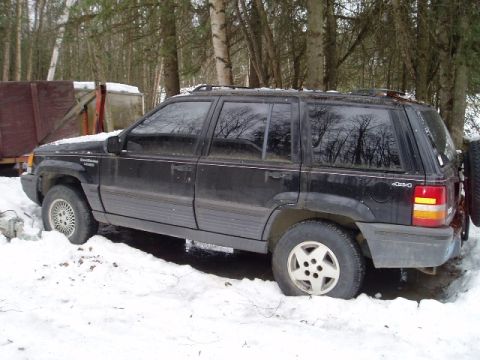 2000 Ford E350 - This black Jeep Grand Cherokee, likely a 1998 model, is seen parked in a snowy wooded area.