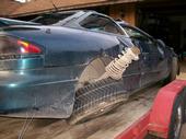 1996 Ford Probe - Rear view of a damaged 1996 Ford Probe with its suspension system visible.