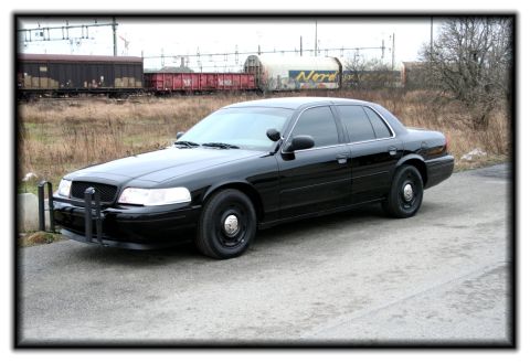 1998 Ford Crown Victoria - This 1998 Ford Crown Victoria features a prominent push bar on its front end, seen from a 3/4 front perspective.