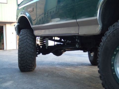 1996 Ford Bronco - Close-up of the suspension and large tires on a lifted 1996 Ford Bronco.