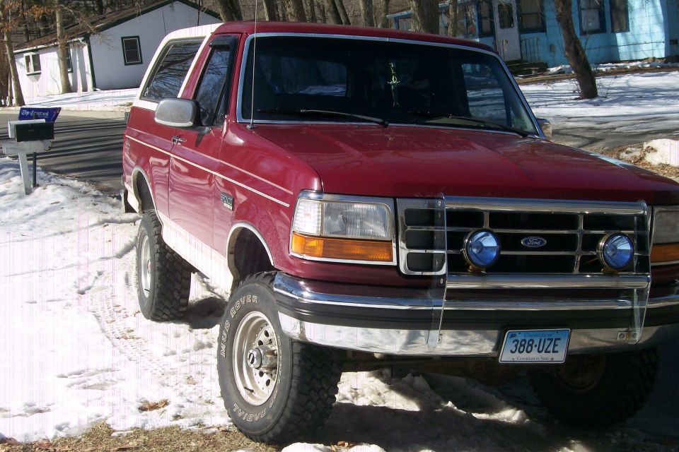 Red 1993 Ford Bronco parked on a snowy street