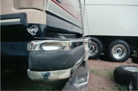 1988 Ford Bronco - Close-up of a vehicle's rear bumper, with a trailer and its wheels in the background.