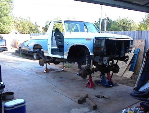 1981 Ford Bronco - This truck is undergoing repairs with its front end disassembled and raised on jack stands.