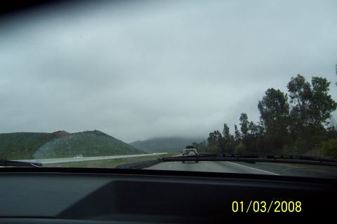 1990 Ford Bronco - Driving on a highway under a cloudy sky with hills and trees visible.