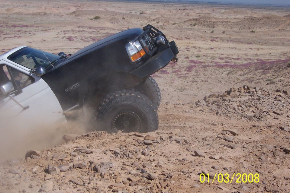 Black 1990 Ford Bronco navigating rough terrain