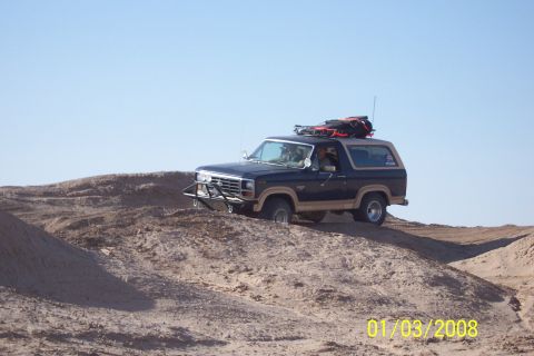 1990 Ford Bronco - This Ford Bronco appears to be from the late 1980s, possibly a 1987 model, as it navigates a sandy terrain.