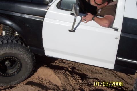 1990 Ford Bronco - This 1990 Ford Bronco features a distinctive two-tone paint scheme on its side, with a prominent off-road tire visible.
