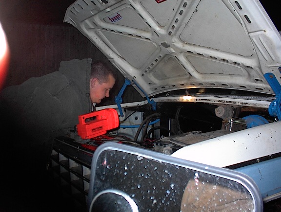 Man with red work light looking at 1981 Ford Bronco engine bay