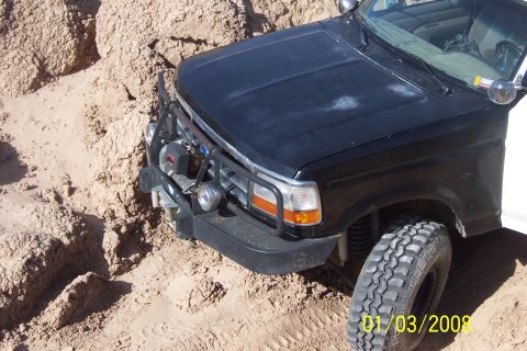 1990 Ford Bronco - This 1990 Ford Bronco is navigating sandy terrain, equipped with a bull bar and winch.