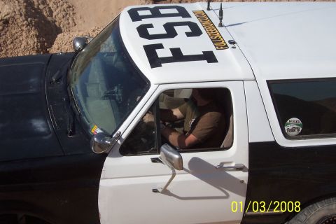 1990 Ford Bronco - A two-tone Ford Bronco with 'FSB' emblazoned on its roof is seen from a 3/4 front angle.
