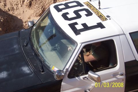 1990 Ford Bronco - SUV with large numbers FS8 and website address on the roof.