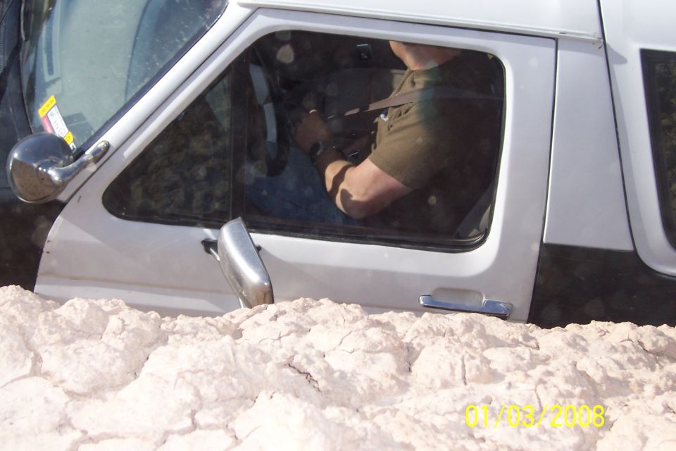 1990 Ford Bronco side view, stuck in dirt with driver inside