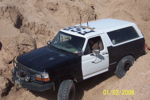 1990 Ford Bronco - This 1990 Ford Bronco is partially buried in sand, with '851' visible on its roof.