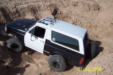 1990 Ford Bronco - This two-tone 1990 Ford Bronco navigates sandy terrain, displaying 'FSB' on its roof.