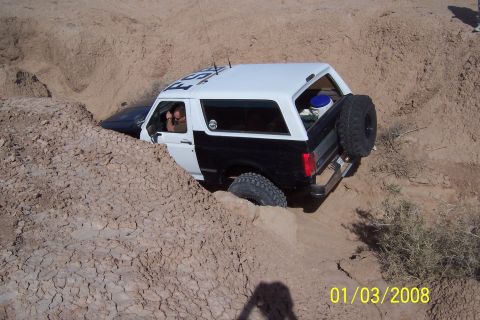 1990 Ford Bronco - This 1990 Ford Bronco is stuck in a steep dirt ravine, with its tires digging into the loose soil.