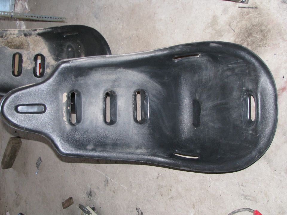 Two black plastic bucket seats with cutouts