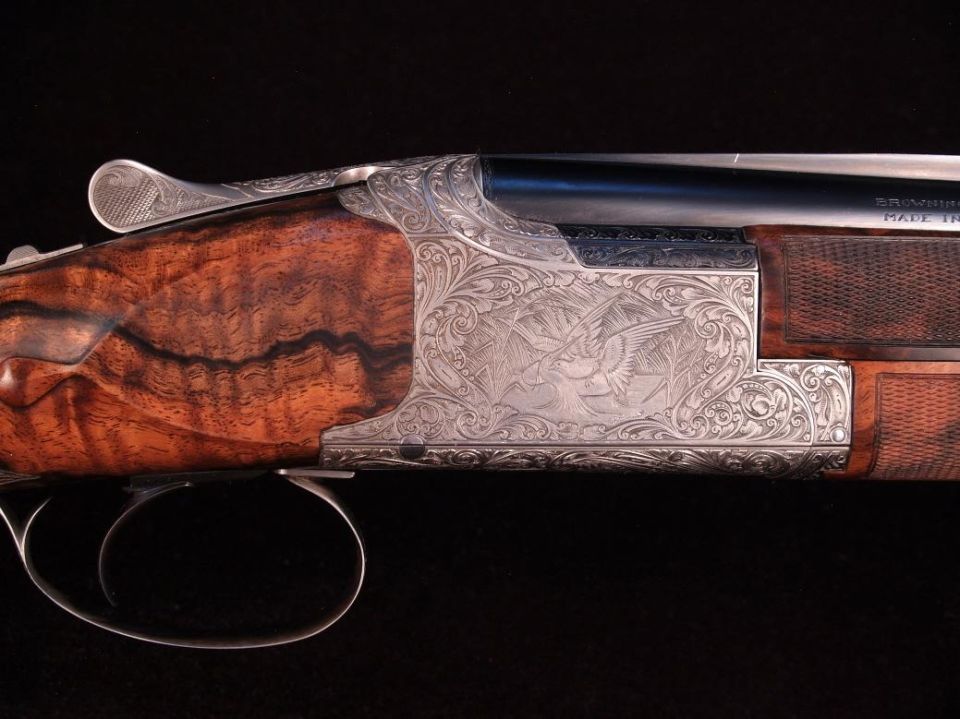 Engraved shotgun receiver and wooden stock
