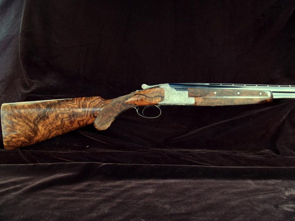 Over-under double-barrel shotgun with engraved receiver and figured walnut stock
