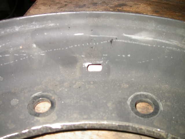 Annoying oblong hole for military valve stem.  Needs to be drilled out to .453"  (29/64")  to accept civilian valve stem.