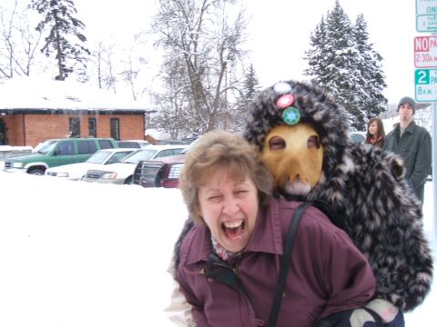 1974 Ford Ranchero - A woman laughs while posing with a person in a furry costume in a snowy parking lot with several cars visible.