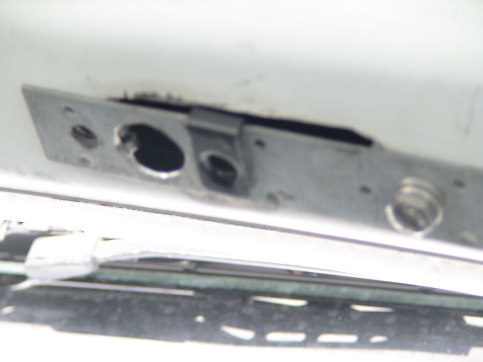 Close-up of a vehicle's metal latch mechanism with springs.