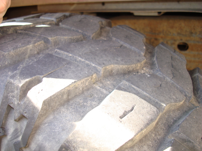 Close-up of a worn off-road tire tread with large lugs.