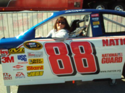 1978 Ford Bronco - A woman wearing sunglasses sits in the driver's seat of a blue and white NASCAR race car with the number 88 prominently displayed on its si…