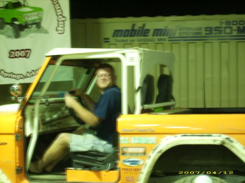 1978 Ford Bronco - Man sits in the driver's seat of an orange Ford Bronco, with a banner in the background indicating '2007 Springs, Arka'.
