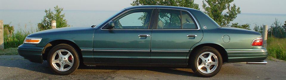 1996 Mercury Grand Marquis sedan, side view, green paint, alloy wheels