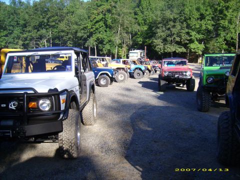 1978 Ford Bronco - A line of Ford Broncos, including a white one in the foreground, are parked outdoors on a sunny day.
