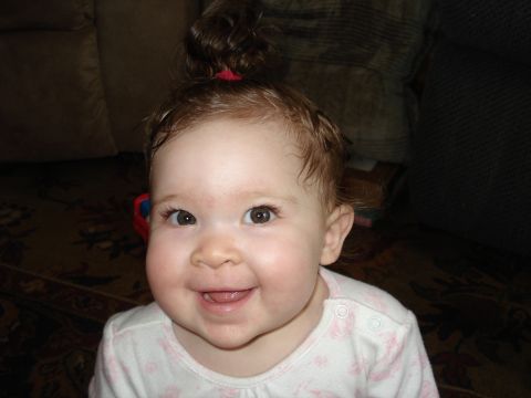 2000 Ford Crown Victoria - A smiling baby girl with curly hair tied in a bun.