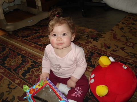 2000 Ford Crown Victoria - A baby sits on a patterned rug, surrounded by toys.