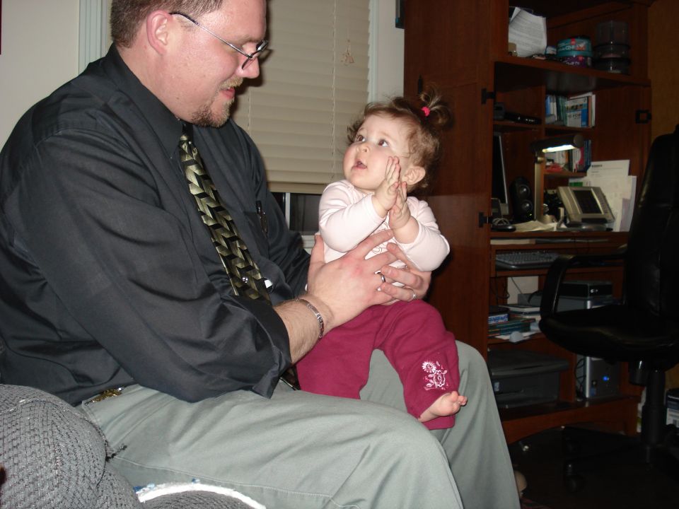 Man holding a baby who is clapping