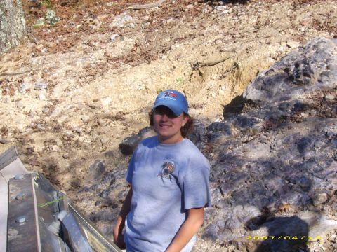 1978 Ford Bronco - A person stands in a rocky, outdoor environment with trees and dirt visible.