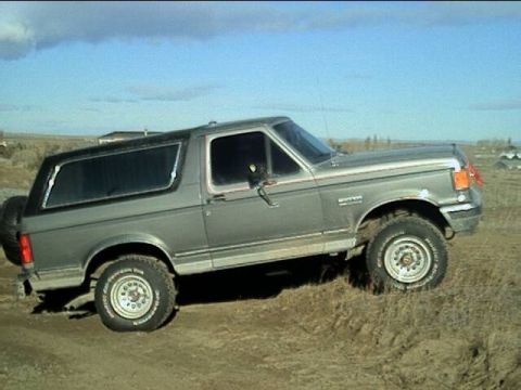 1989 Ford Bronco - This 1989 Ford Bronco is parked on a dirt lot under a cloudy sky.