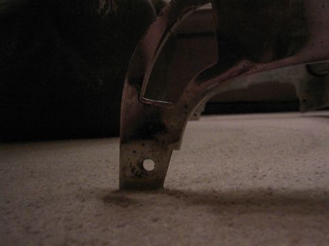 1987 Ford Bronco - A close-up of a chrome trim piece, possibly from a vehicle, resting on a carpeted surface. The number '375' is visible on the part.