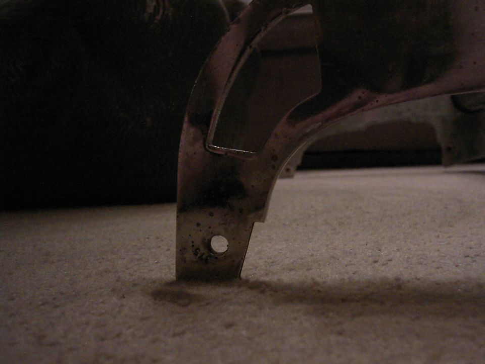 Chrome trim piece with visible '375' marking on carpet