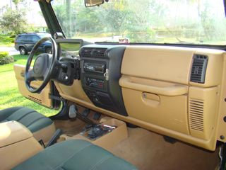 1998 Jeep Wrangler - The interior of a Jeep Wrangler is shown, with a second vehicle visible through the window.