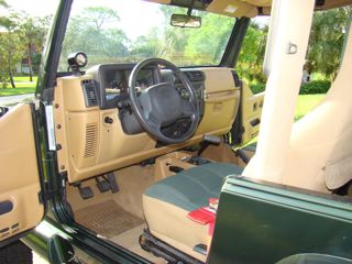 1998 Jeep Wrangler - Interior view of a green Jeep Wrangler, tan dashboard and seats.