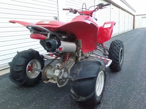 1995 Ford Bronco - This red ATV has large paddle tires on the rear and an aftermarket exhaust system.