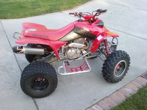 1995 Ford Bronco - This red Honda ATV is parked on a concrete driveway.